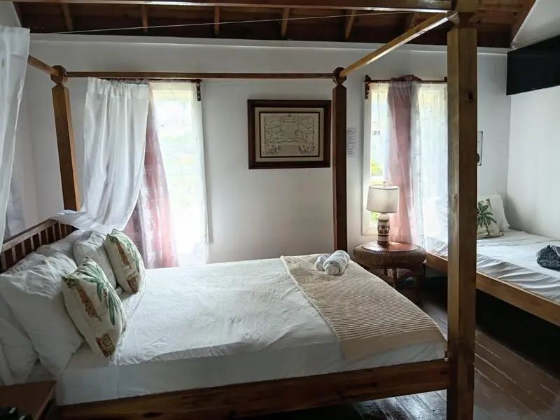 Une chambre lumineuse avec un lit à baldaquin et une décoration florale.