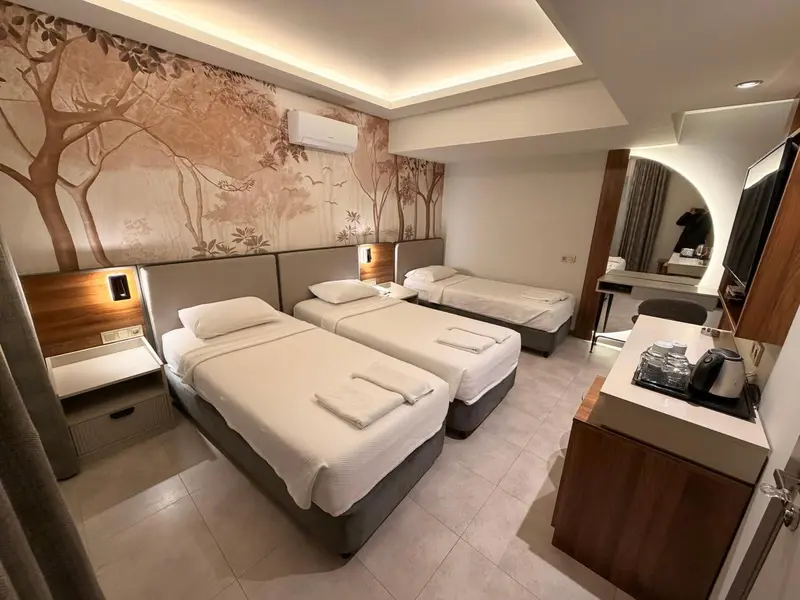 Chambre avec deux lits simples et un lit d'une place.