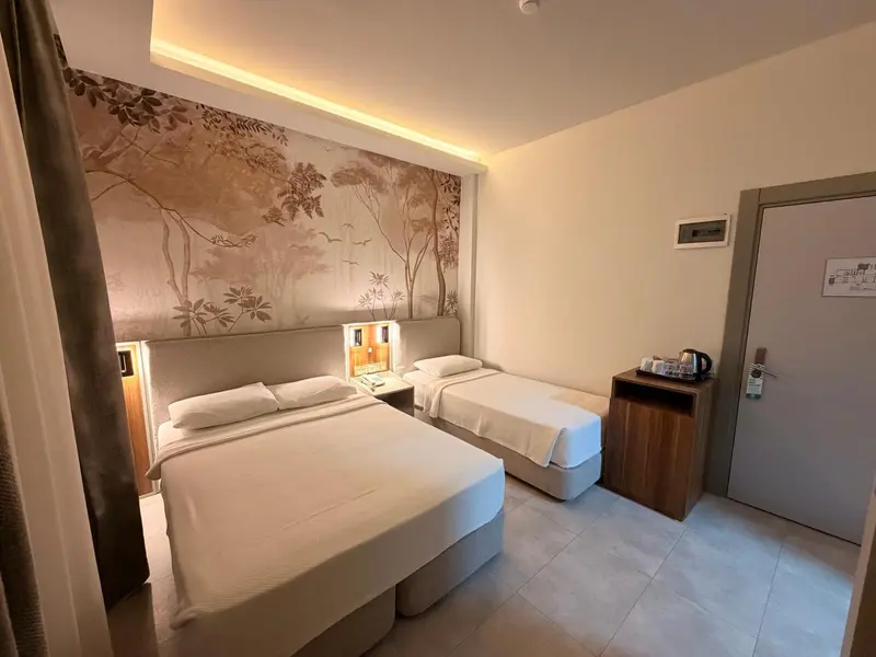 Une chambre avec deux lits simples et une décoration murale.
