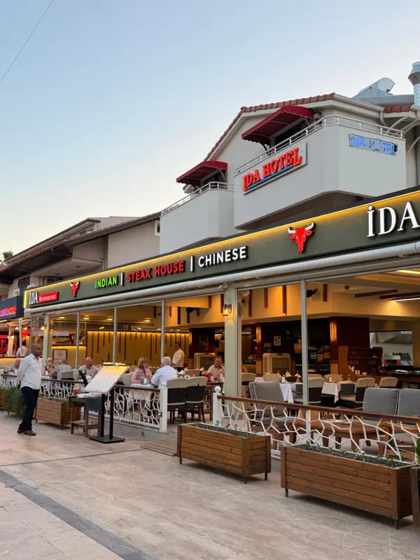 Terrasse de restaurant avec tables et chaises devant un bâtiment.