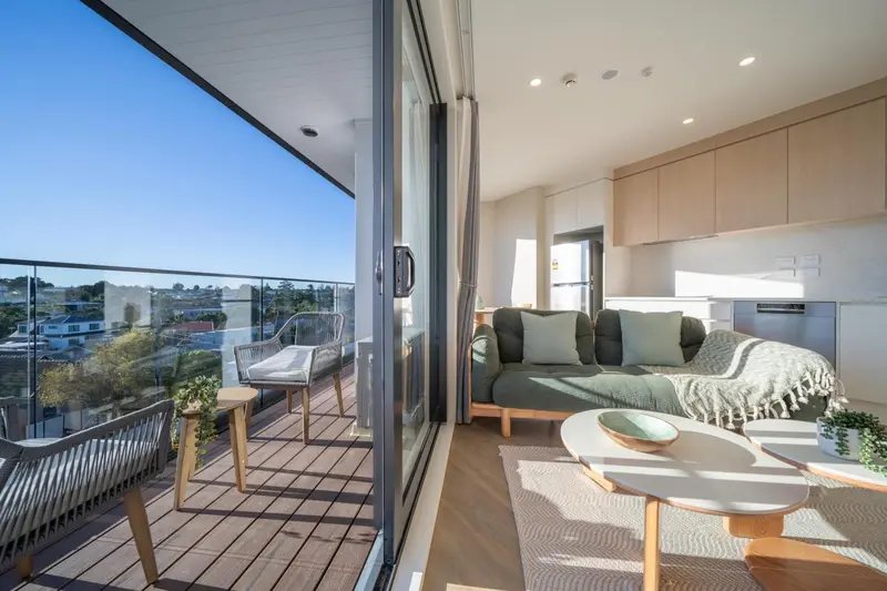 Un salon lumineux s'ouvre sur une terrasse avec vue sur la ville.