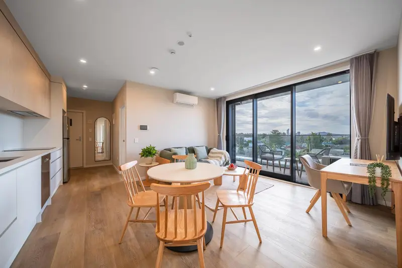Espace de vie lumineux avec coin repas et accès à une terrasse.