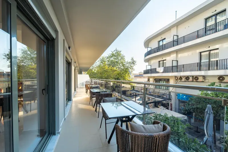 Terrasse aménagée avec tables et chaises, vue sur un bâtiment.