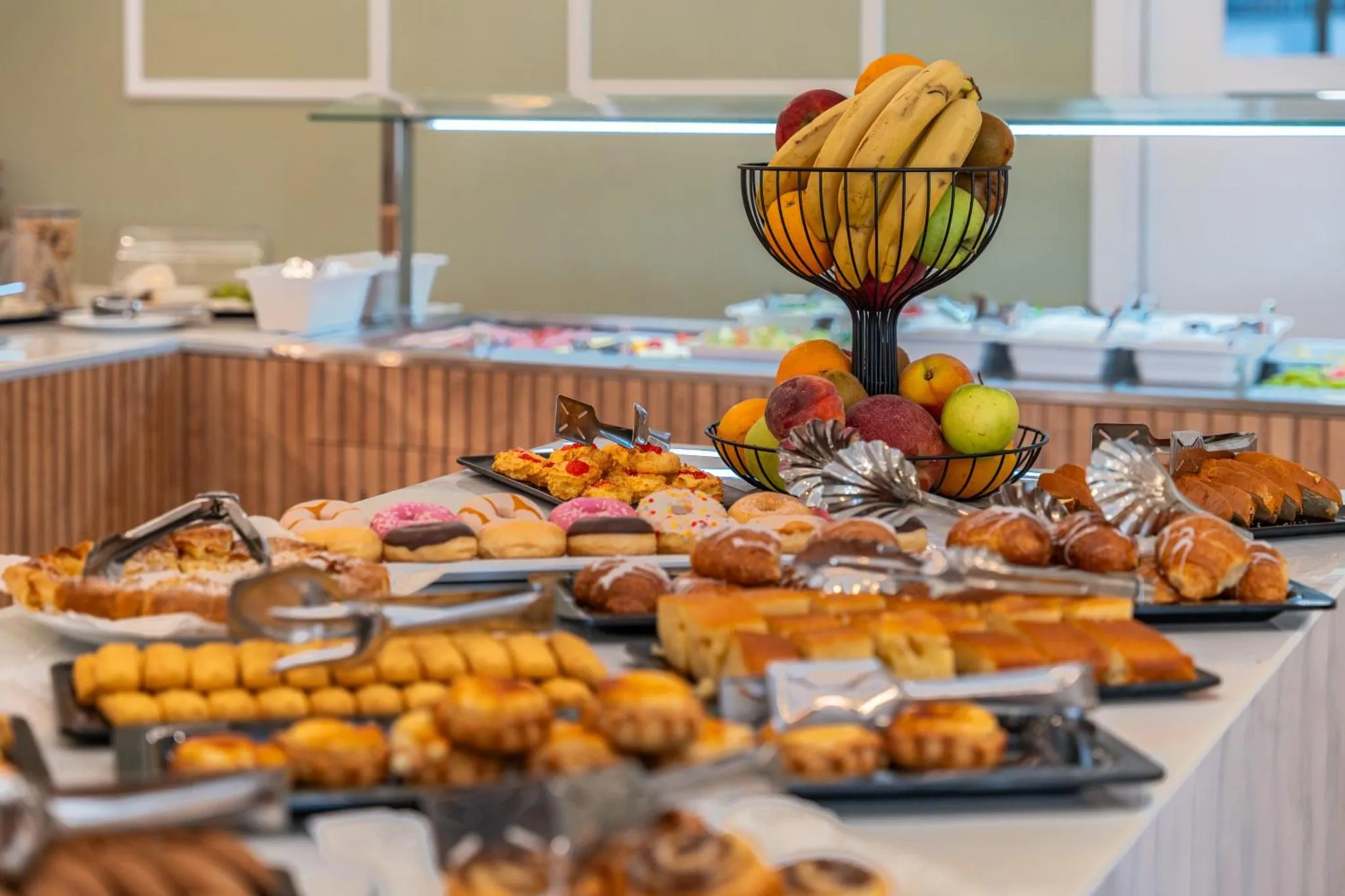 Un buffet propose une variété de pâtisseries et de fruits frais.