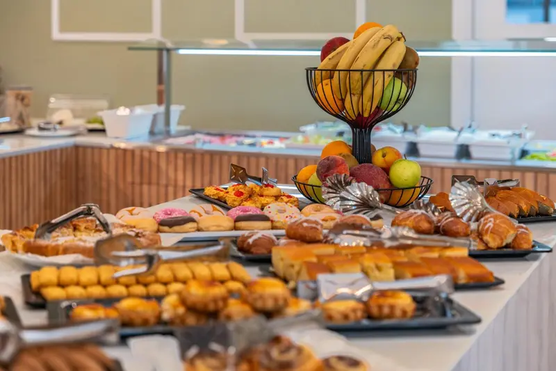 Un buffet propose une variété de pâtisseries et de fruits frais.