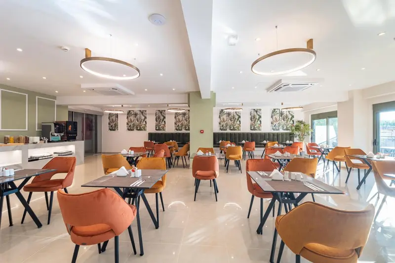 Une salle lumineuse avec des tables dressées pour le repas.