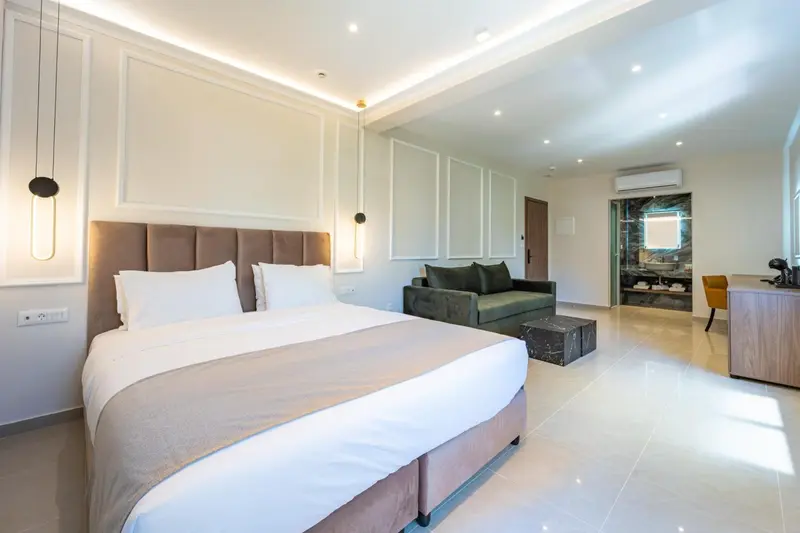 Une chambre lumineuse avec un grand lit et un coin salon.