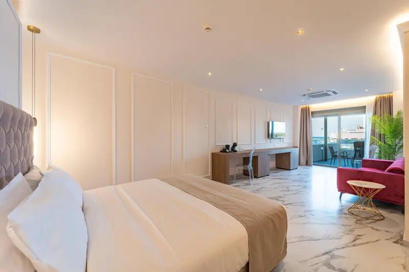 Chambre lumineuse avec un grand lit et un espace détente.
