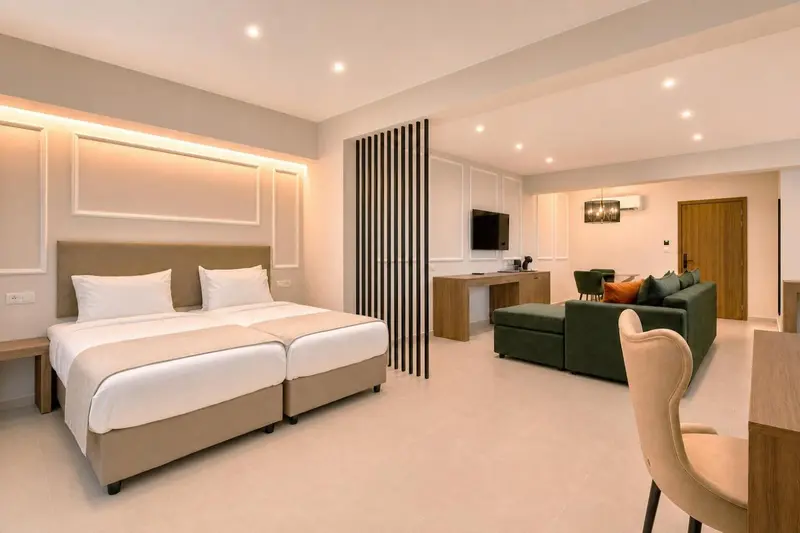 Une chambre lumineuse avec un grand lit et un espace salon confortable.