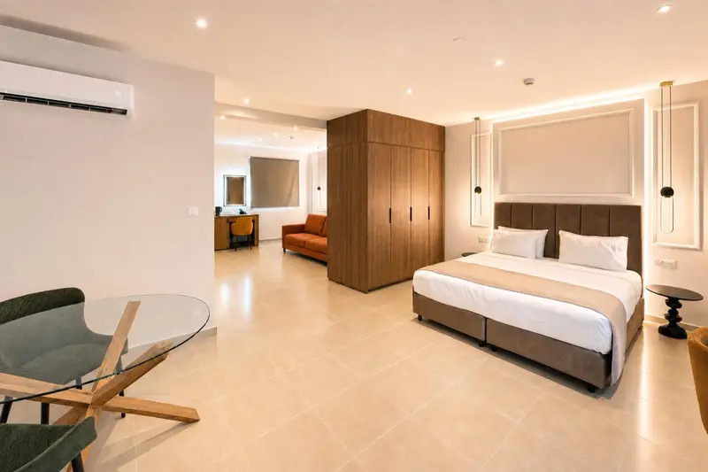 Une chambre lumineuse avec un grand lit et un coin salon.