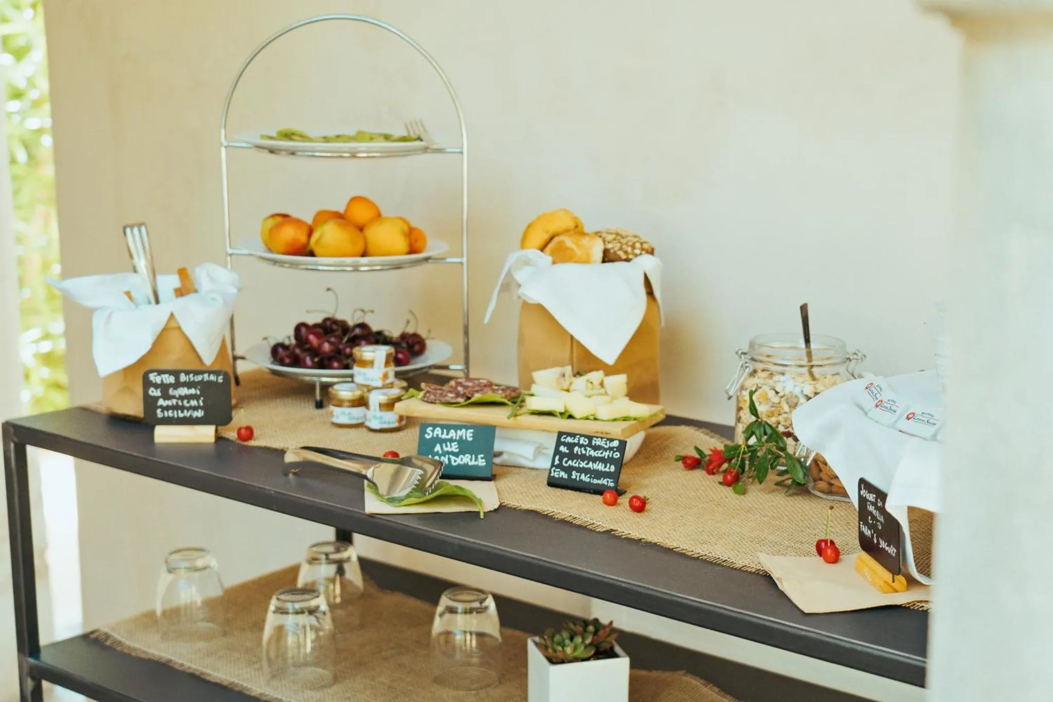 Un buffet propose des fruits frais, des viennoiseries et des confitures.