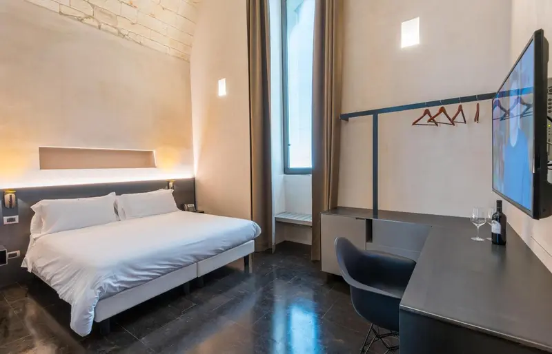 Une chambre lumineuse avec un grand lit et un bureau.
