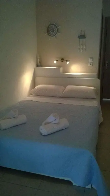 Une chambre lumineuse avec un grand lit recouvert d'une couverture bleue.