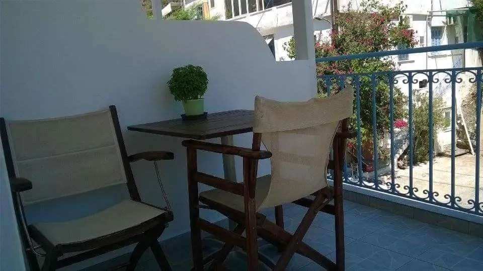 Deux chaises et une petite table sur une terrasse ensoleillée.