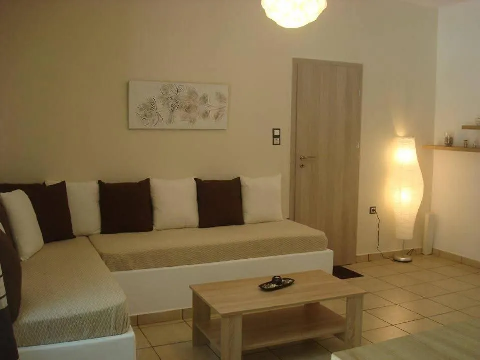 Un canapé d'angle beige et des coussins sombres sont disposés devant une table basse en bois.