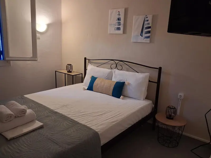 Une chambre lumineuse avec un lit double et une décoration sobre.