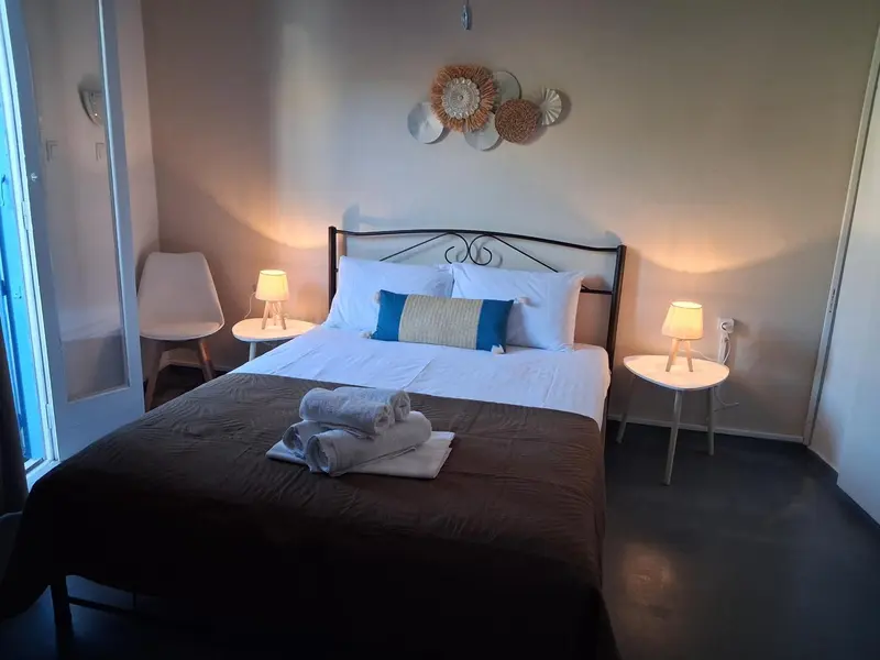 Une chambre lumineuse avec un lit double et des tables de chevet.