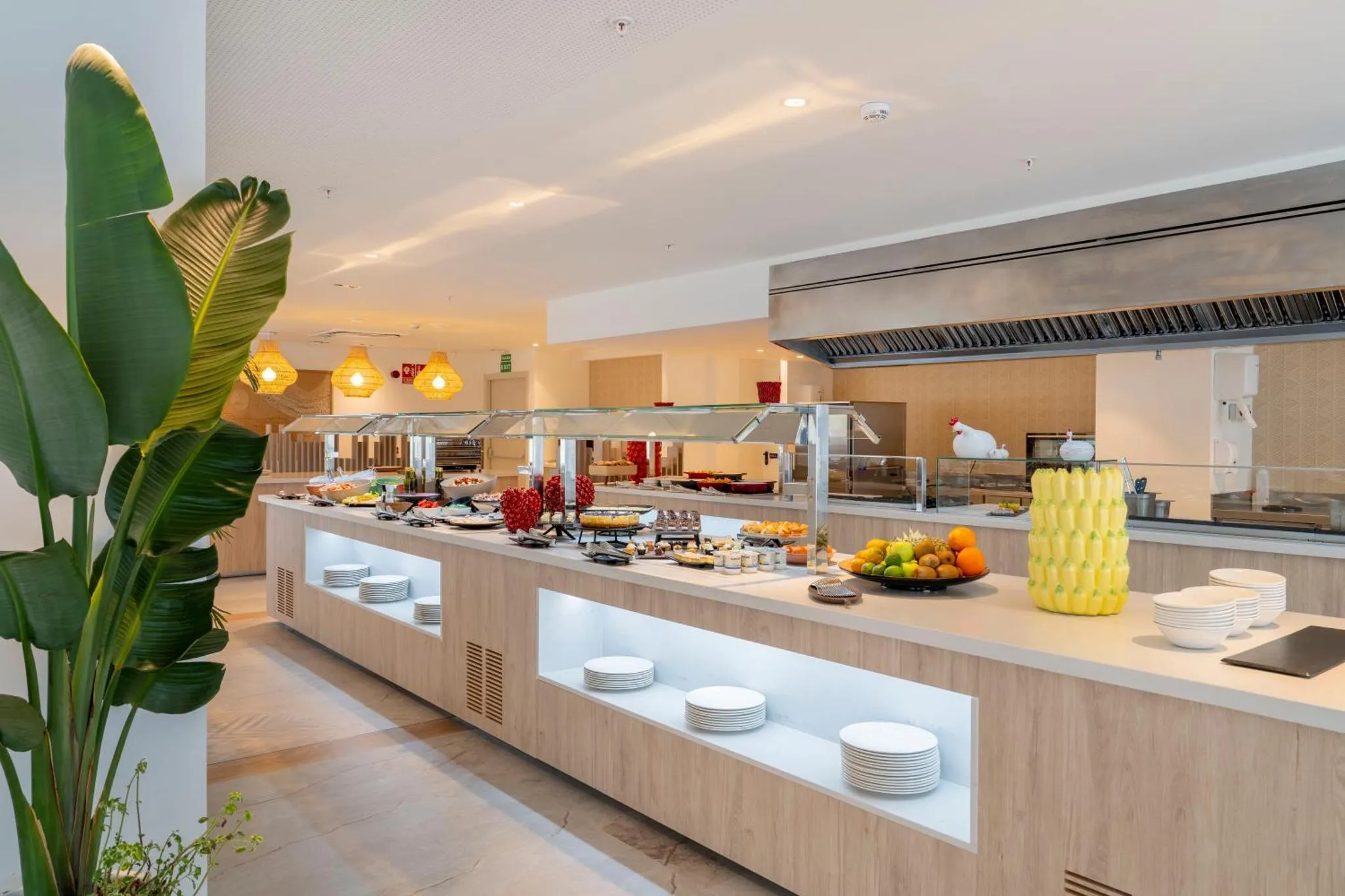 Un buffet propose une variété de plats et de fruits frais dans une salle lumineuse.