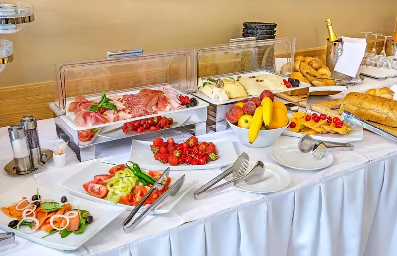 Un buffet propose une variété de charcuteries, de fruits frais et de salades.