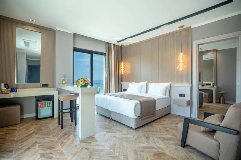 Chambre lumineuse avec un grand lit et un espace détente.