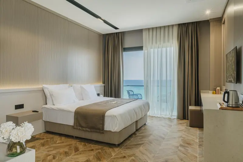 Une chambre lumineuse avec un grand lit et une vue sur la mer.