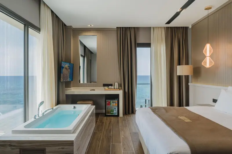 Une chambre avec baignoire et vue sur la mer.