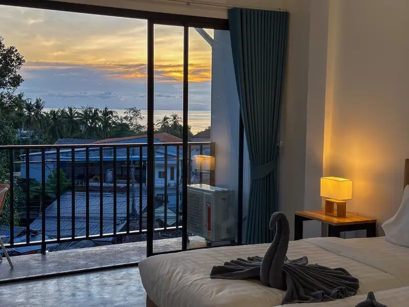 Une chambre lumineuse avec un lit soigné donnant sur une vue panoramique.