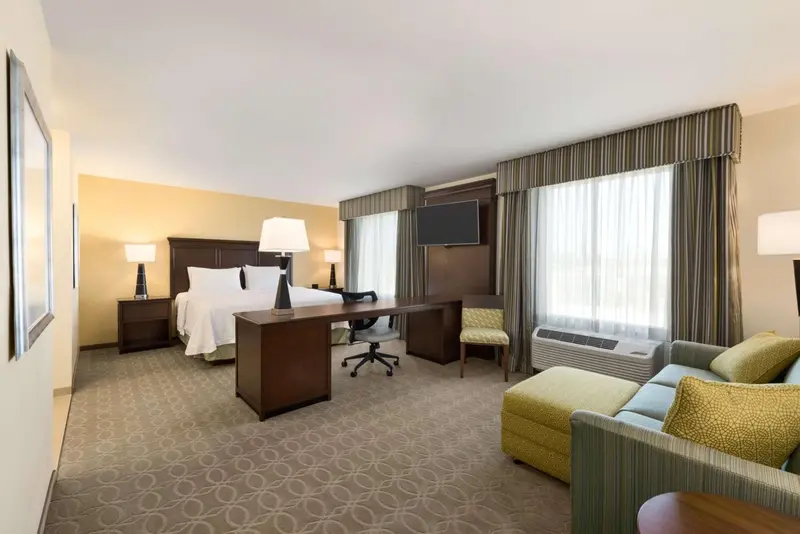Une chambre d'hôtel lumineuse avec un grand lit et un espace bureau.