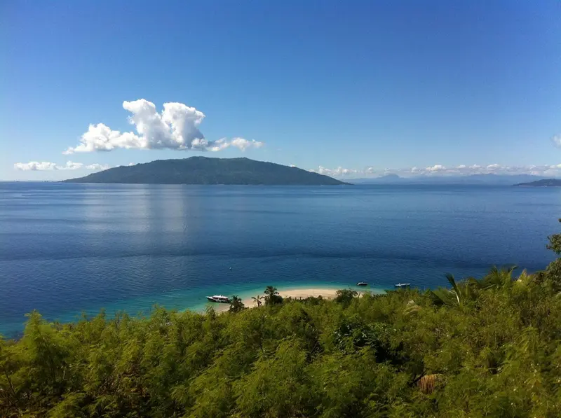 Vue panoramique sur une île tropicale et la mer scintillante.