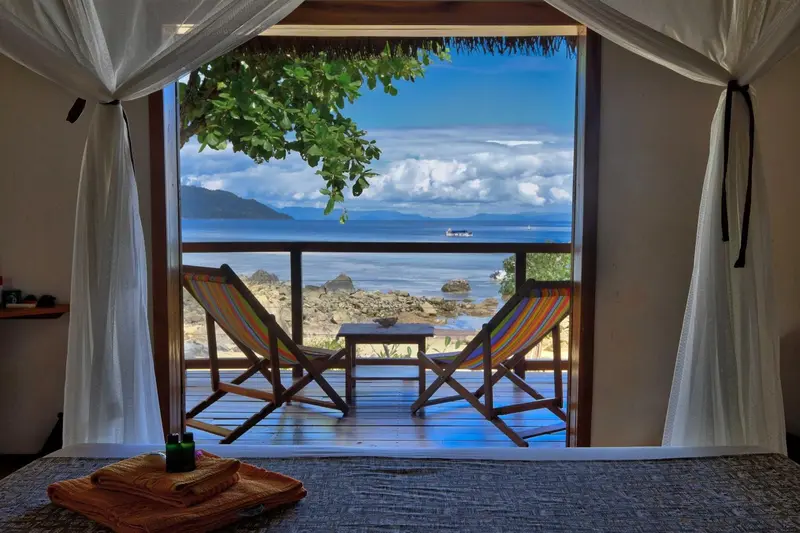 Vue sur la mer depuis une terrasse avec deux fauteuils.
