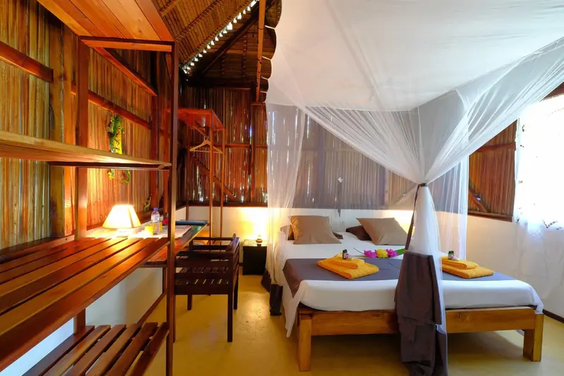 Une chambre lumineuse avec un lit à baldaquin et une décoration en bois.
