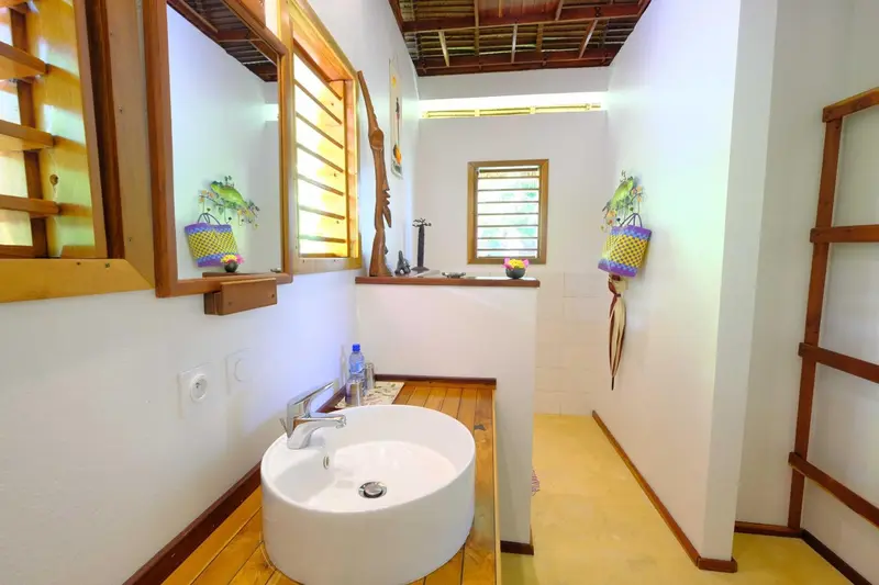 Une salle de bain lumineuse avec lavabo et douche à l'italienne.