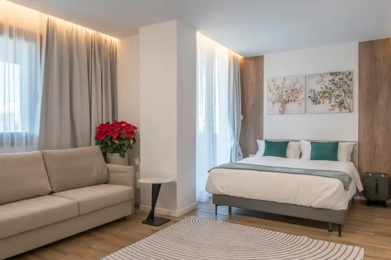 Une chambre lumineuse avec un canapé et un grand lit.