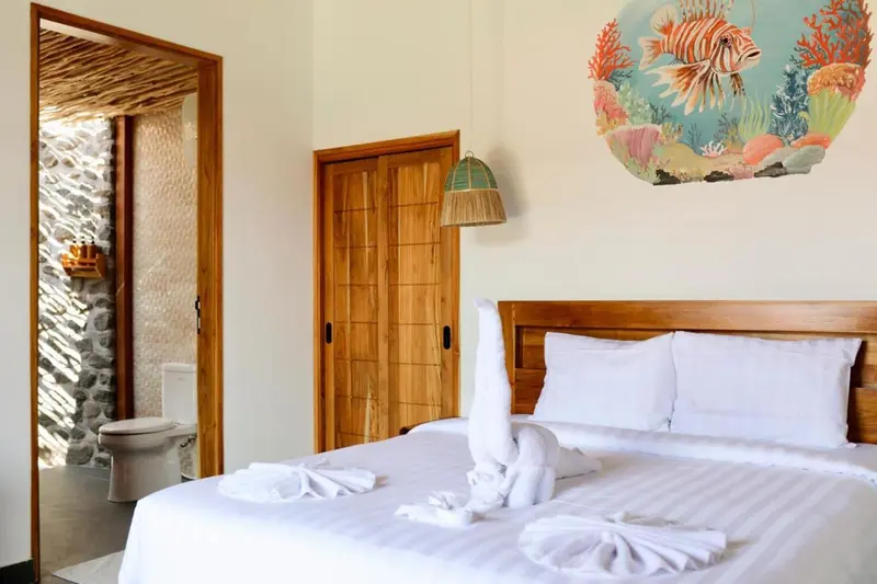 Une chambre lumineuse avec un lit décoré de serviettes en forme d'animaux.