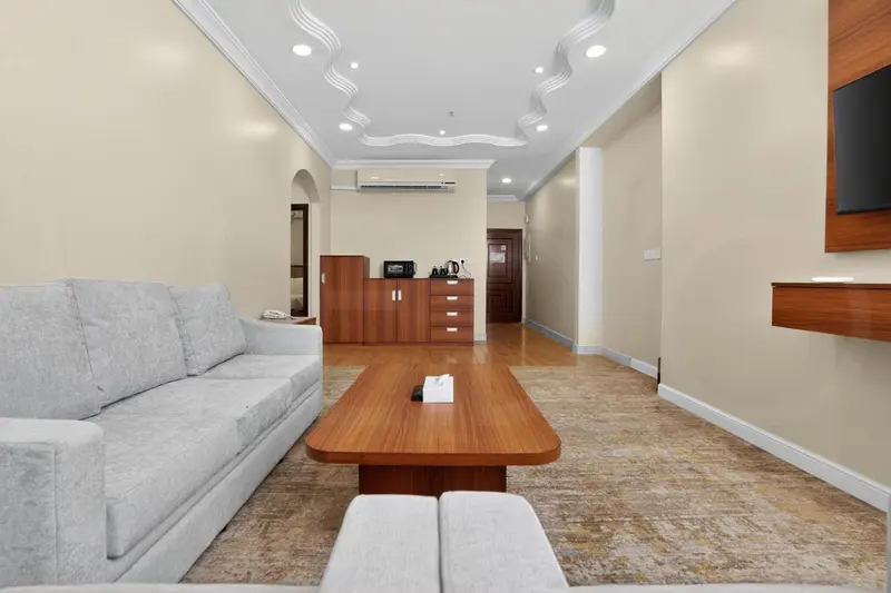 Un salon clair avec un canapé gris et une table basse en bois.