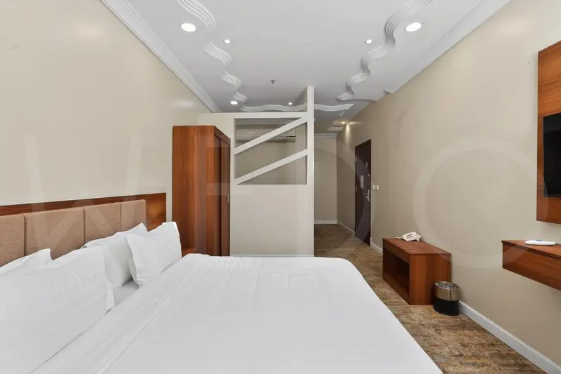 Une chambre lumineuse avec un grand lit et un espace ouvert.