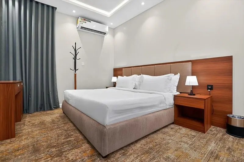 Une chambre lumineuse avec un grand lit et un décor sobre.