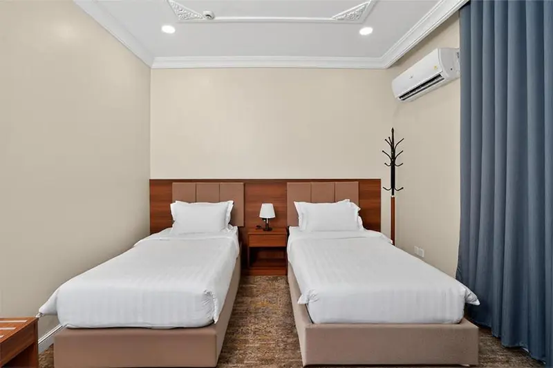 Une chambre avec deux lits simples et une décoration sobre.