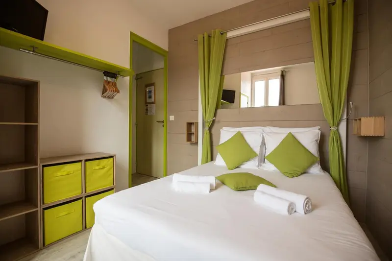 Une chambre lumineuse avec un lit double et un espace de rangement ouvert.