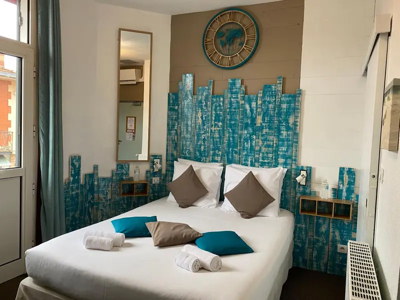 Une chambre lumineuse avec un grand lit décoré de coussins.