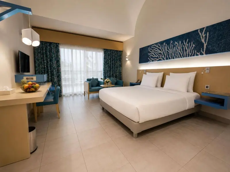 Chambre lumineuse avec un grand lit et un espace détente.