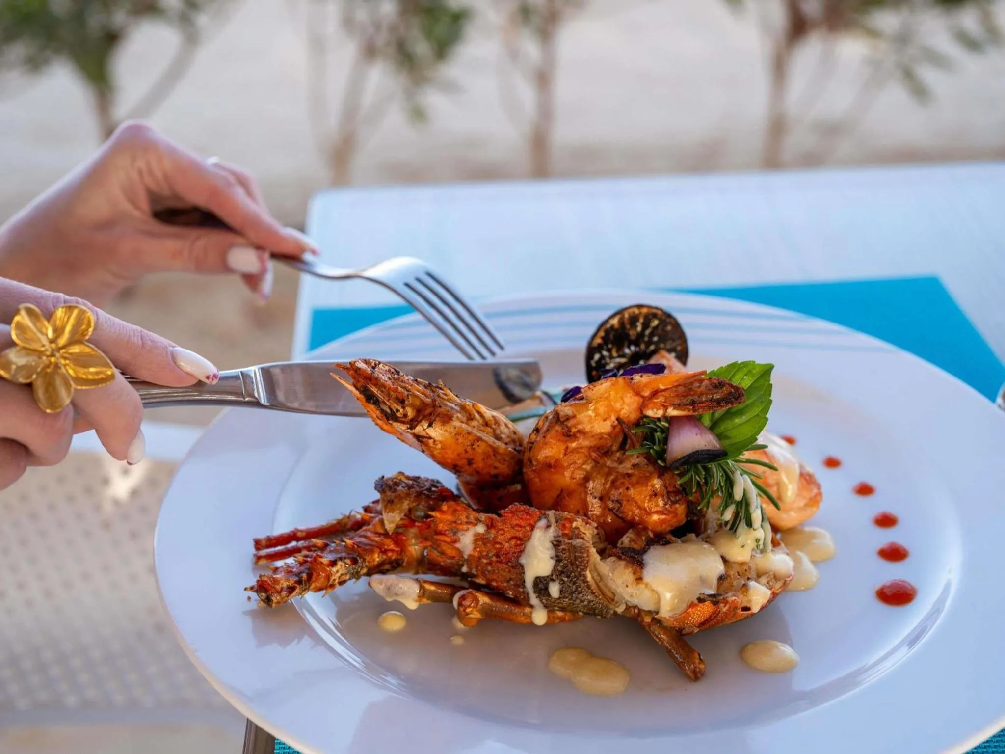 Une assiette de crevettes décorées est coupée avec une fourchette et un couteau.