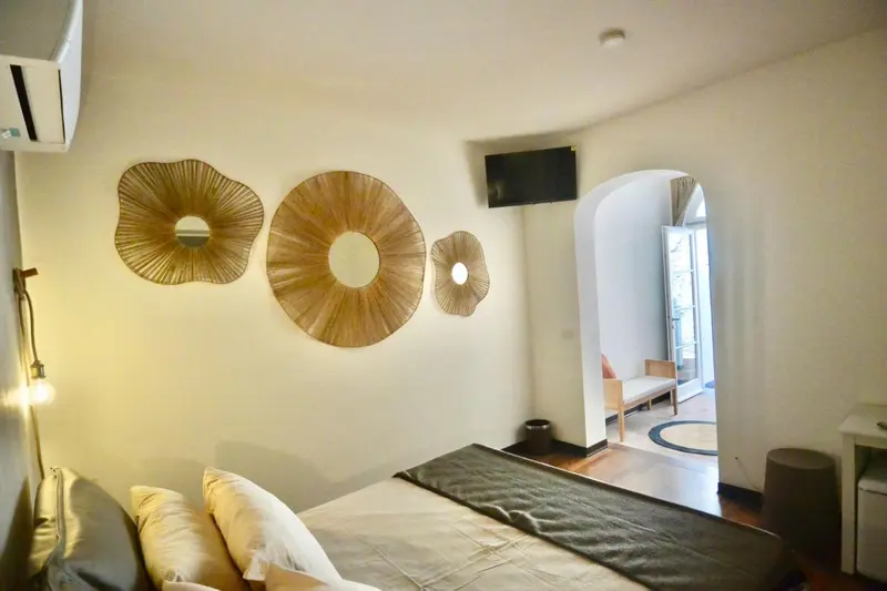 Une chambre lumineuse avec un lit et une décoration murale en forme de fleurs.