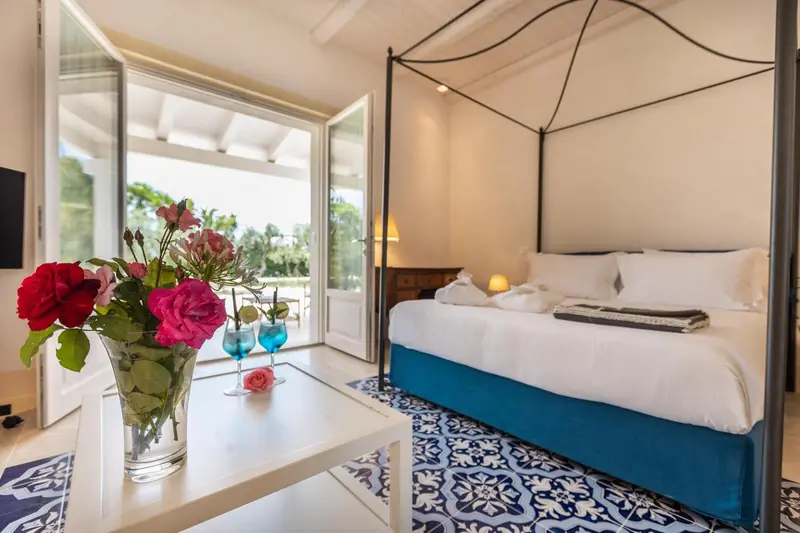 Une chambre lumineuse avec un lit à baldaquin et vue sur l'extérieur.