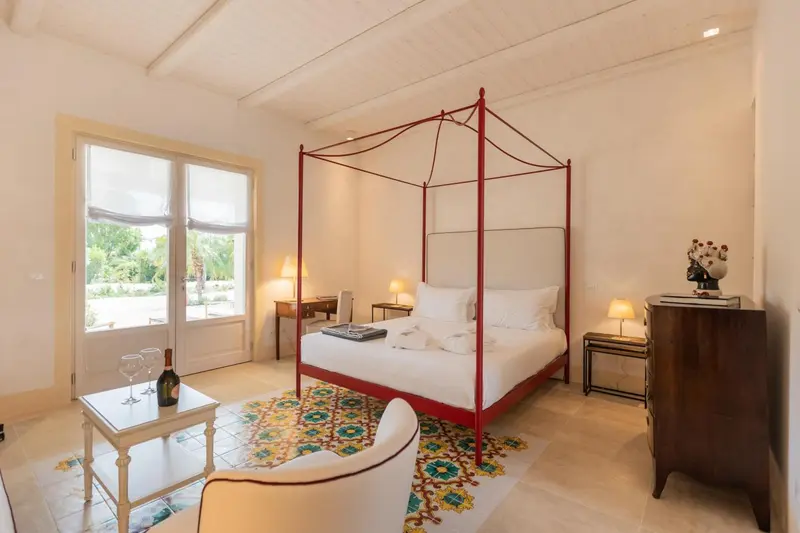Une chambre lumineuse avec un lit à baldaquin et une décoration florale.