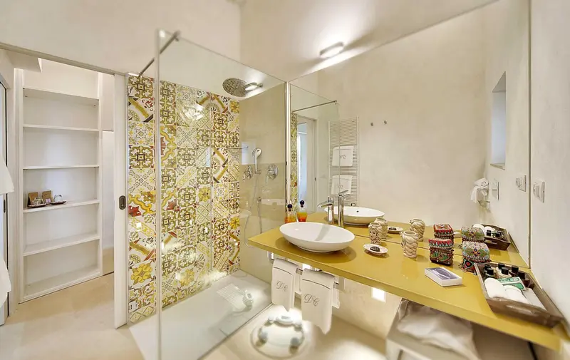 Une salle de bain lumineuse avec une douche à l'italienne et un lavabo sur un meuble.