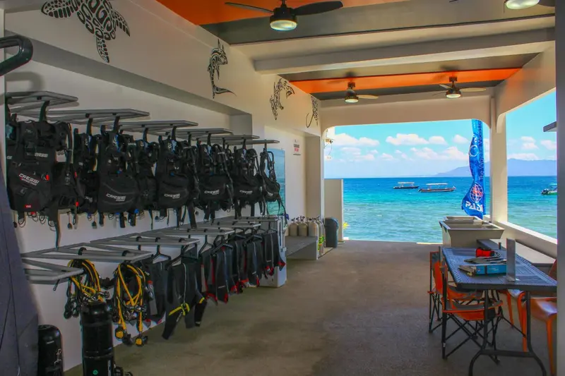 Espace ouvert avec des équipements de plongée suspendus et une vue sur la mer.