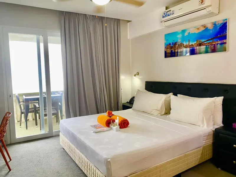Une chambre lumineuse avec un grand lit et un accès à une terrasse.