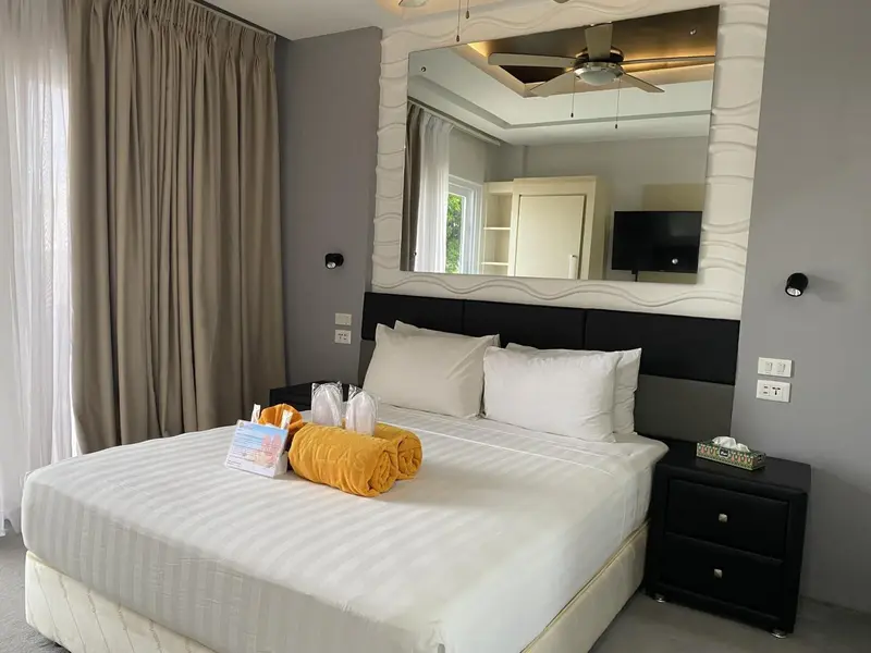 Une chambre lumineuse avec un grand lit et un miroir décoratif.