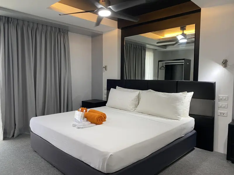 Une chambre lumineuse avec un grand lit recouvert de draps blancs.